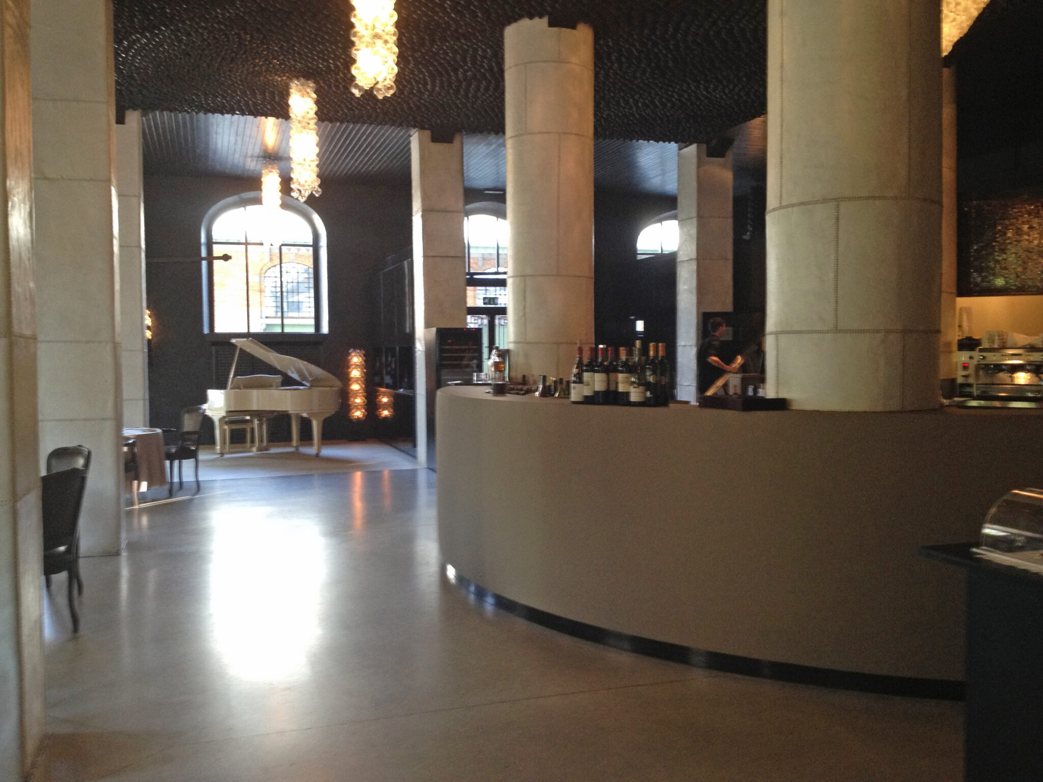 Restaurant Tasso bar cuir décor épuré béton sol luminaire suspension verre